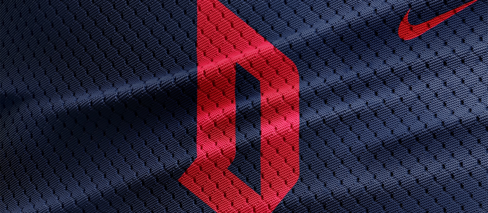 Close-up of Duquesne logo on navy blue jersey