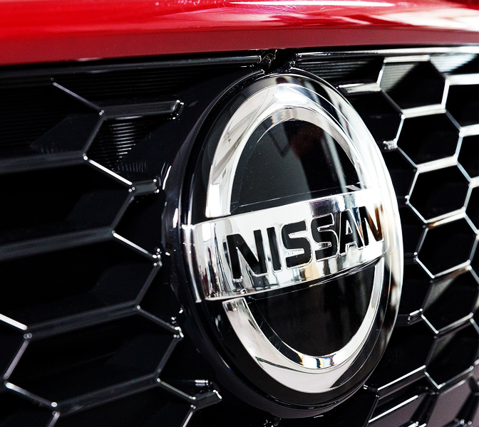 Nissan emblem on front of red car