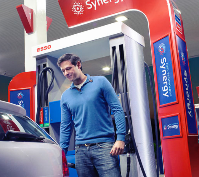Customer filling up gas at ExxonMobil Synergy station